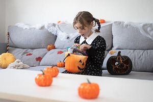 Girl opening Halloween candy bucket with surprised face, a Person Photo by etorres69