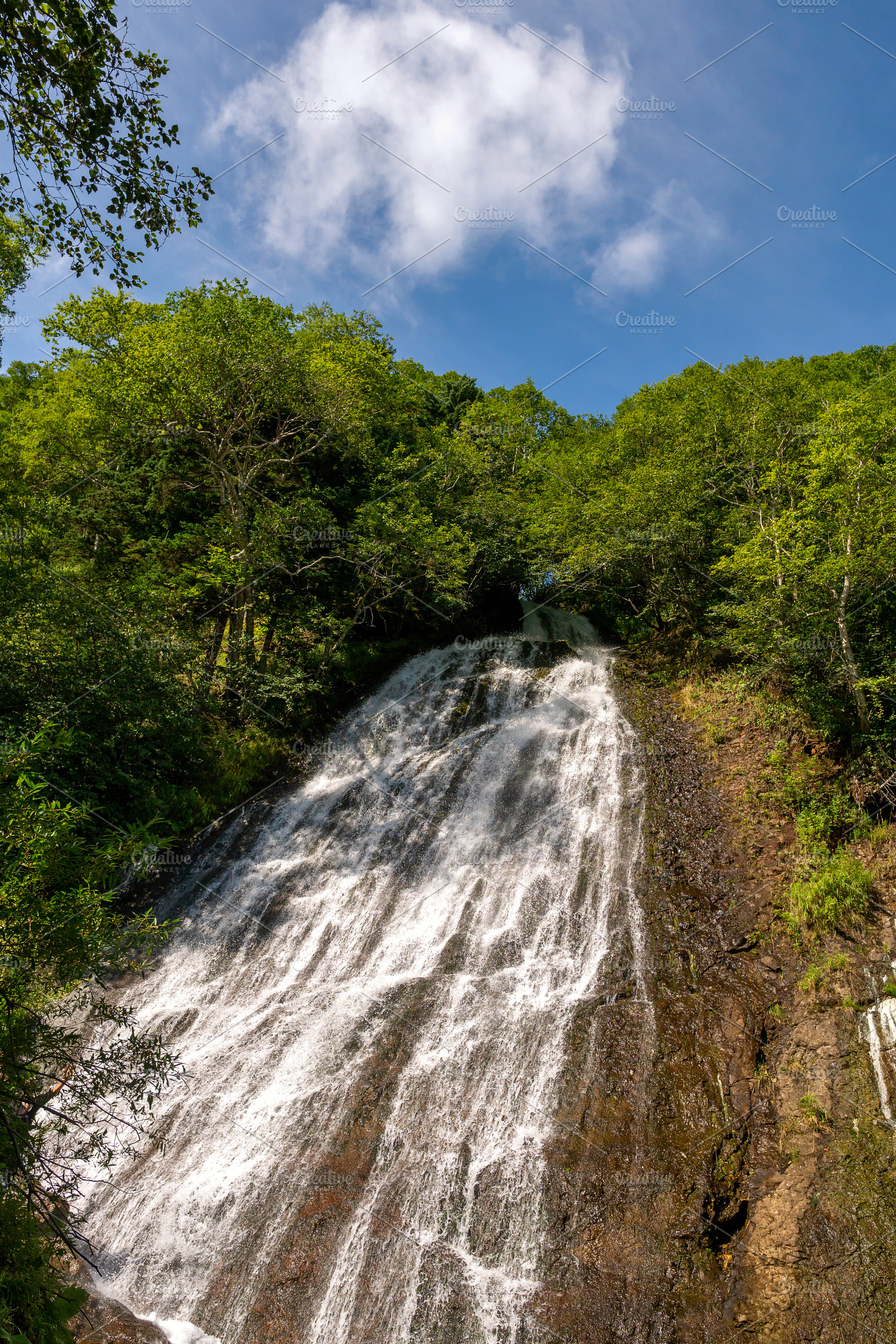 Waterfall flowing beneath bright sky, a Nature Photo by Elena Vagengeim