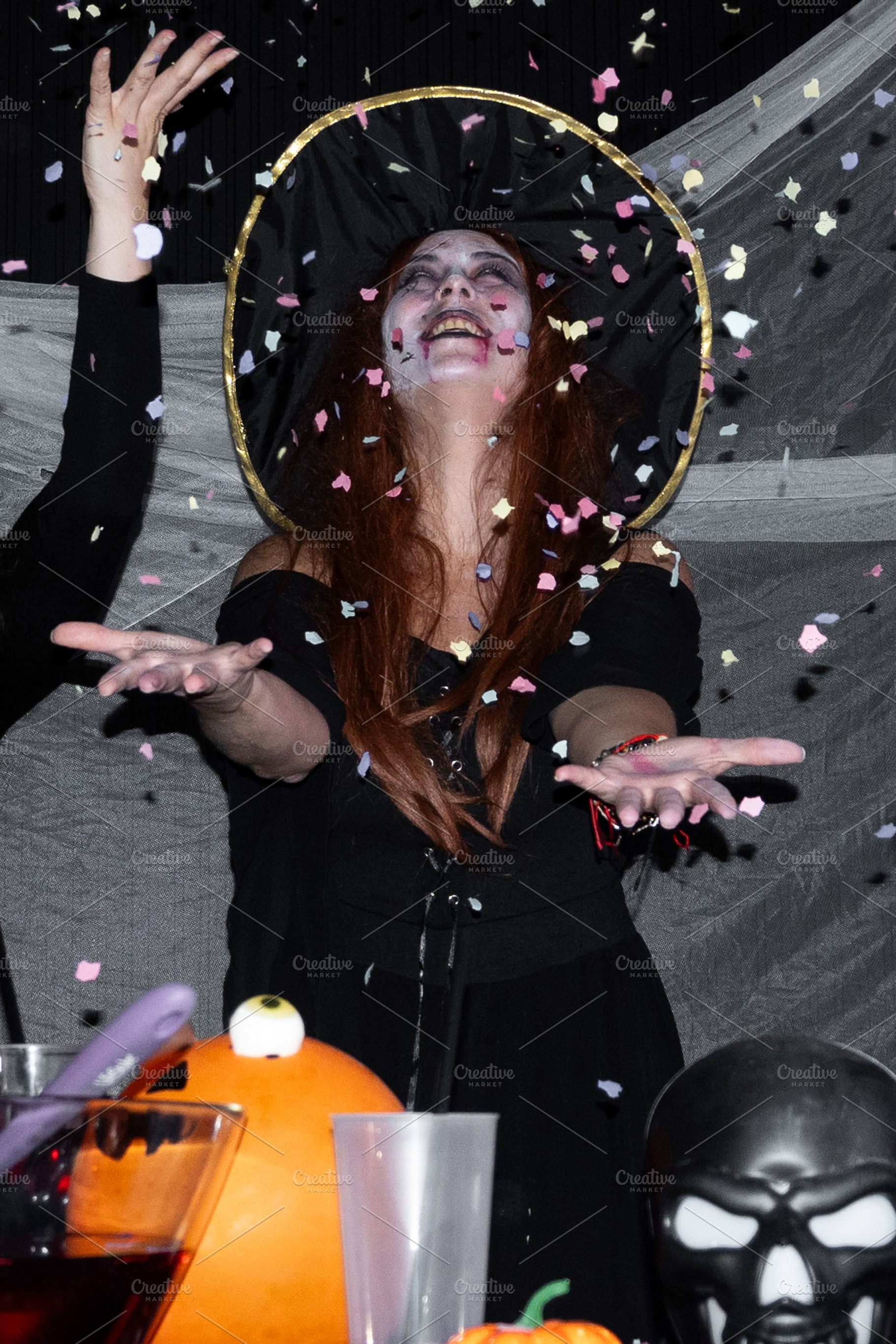Woman dressed as witch celebrating Halloween party with confetti, a Person Photo by etorres69