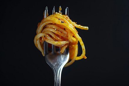 Spaghetti rolled on a fork on black background, a Food & Drink Photo by AlyaAnd