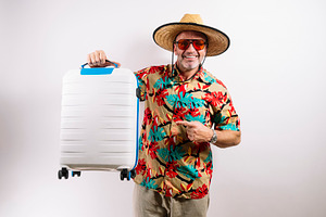 Smiling tourist holding white suitcase, a Holiday Photo by karrastock