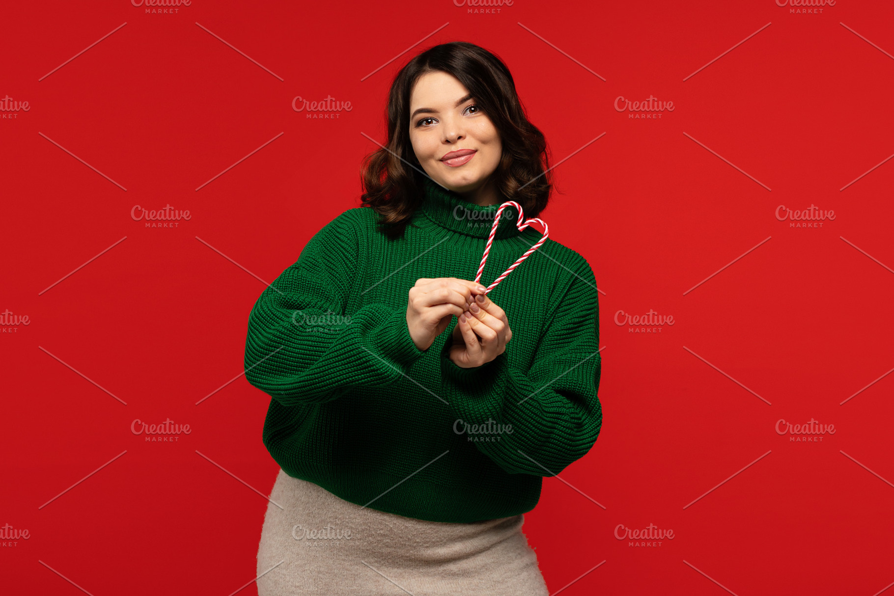 Woman in green sweater holding candy, a Person Photo by Elena Vagengeim