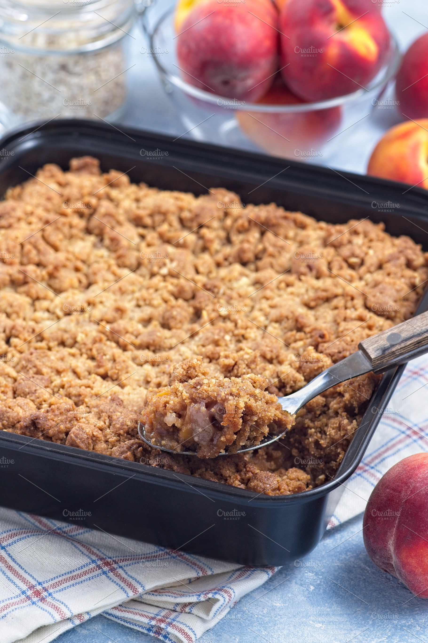 Peach Crisp or cobbler with brown sugar and oat streusel in backing dish, verti, a Food & Drink Photo by iuliia_n