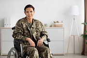 Portrait Of Smiling Female Soldier In Camouflage Uniform Sitting In Wheelchair, a Photo by Prostock-Studio (Thumbnail 1 of 2)