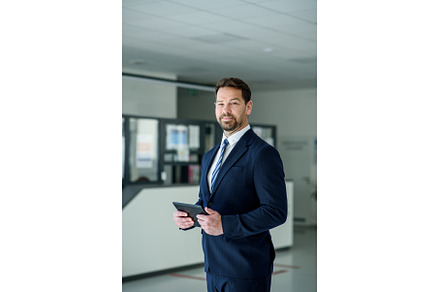 Business professional standing with, a Business Photo by HalfPoint