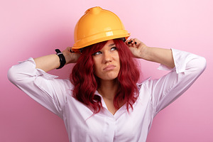 Confident woman with red hair wearing a construction helmet, pos, a Person Photo by Ales Munt