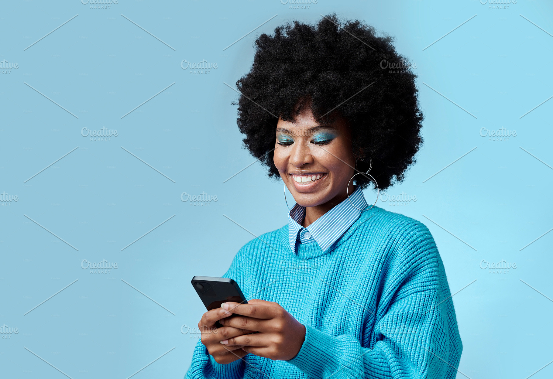 Mockup, smile and black woman with phone typing a online communication message to a contact using social media app. Retro, vintage and happy girl with afro hair doing a internet, web or online search, a Photo by Peopleimages.com
