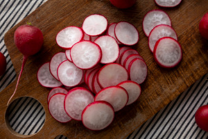 Raw Red Radish Slices on a Cutting Board, top view. Flat lay, ov, a Food & Drink Photo by LiudmylaChuhunova