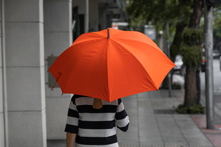 Back view of woman with orange containing umbrella, beautiful, and rain, a Person Photo by volodymyrshtun13795