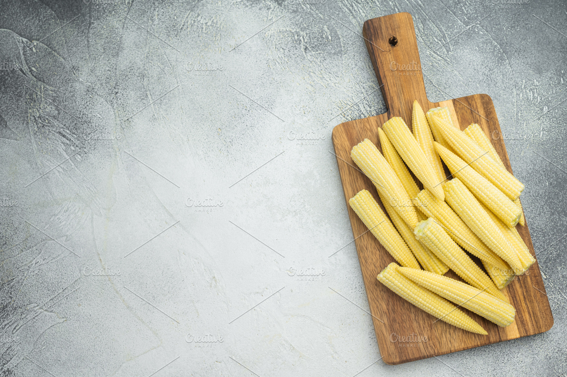 Raw baby corn maize arranged on rustic chopping board top view w, a Food & Drink Photo by composter-box@mail.ru