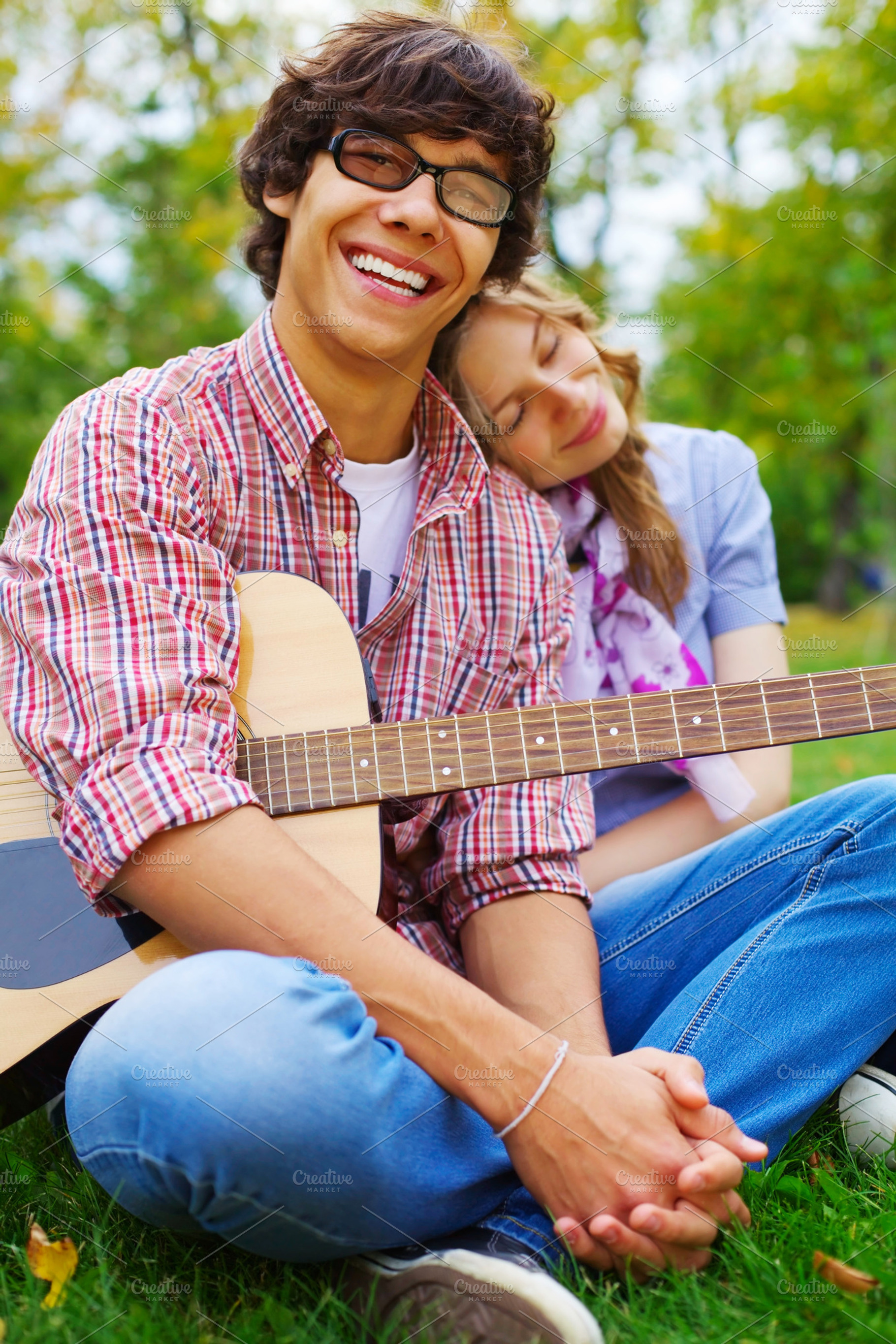 Teenage Couple With Guitar In Park