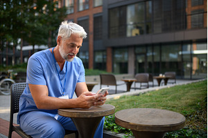 Healthcare worker outside hospital, a Health & Medical Photo by HalfPoint