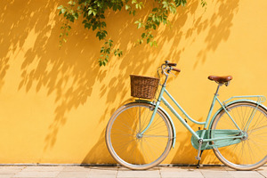Bicycle leans against yellow wall, a Photo by Beautiful things