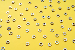 Metal nuts pattern on yellow