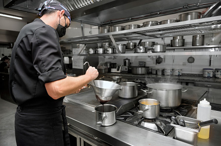 Chef cooking in modern industrial kitchen., a Person Photo by david.herraez.calzad