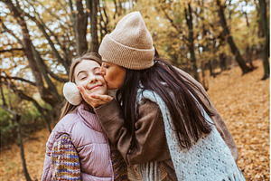 Mother kissing daughter on cheek, a Person Photo by HalfPoint