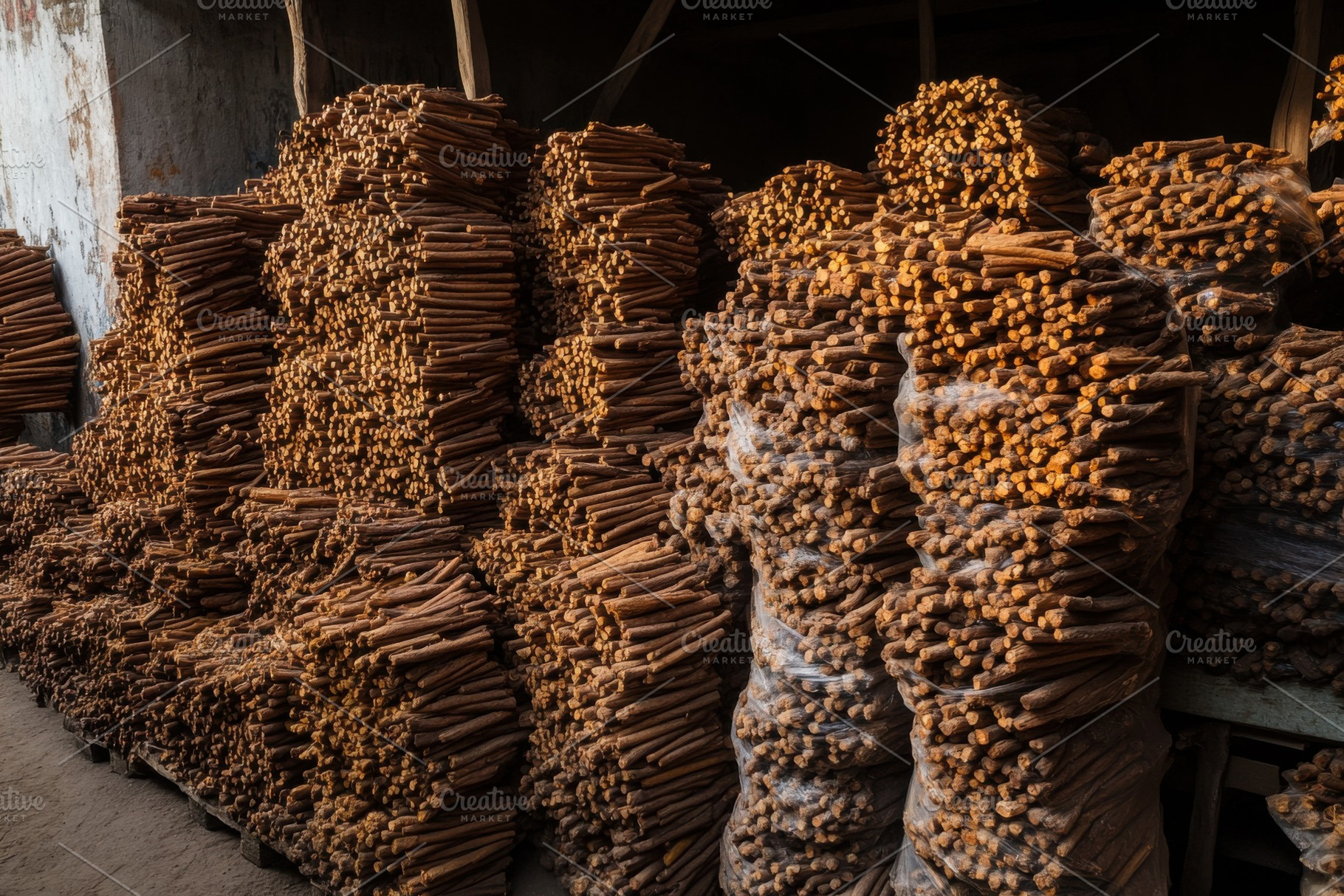 Piles of cinnamon sticks stacked in, a Photo by Iftikhar Alam
