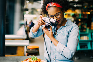 Young woman photographing her food on a cafe counter, a Person Photo by Stefan & Janni