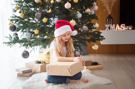 A girl with gifts plays near the Christmas tree., a Holiday Photo by Olena Rudo