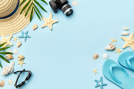 Summer accessories creating frame on light blue background with