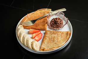 A plate of crepes filled with chocolate spread and topped with b, a Food & Drink Photo by Budarinphoto