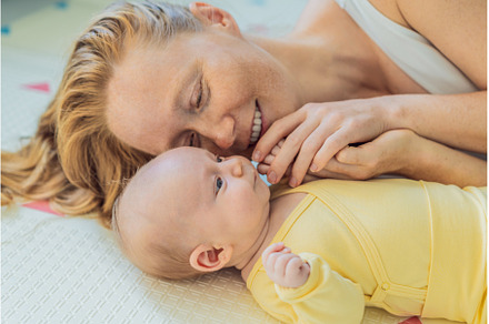Mother and baby lying on a play mat