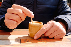 man stirring a cup of french noisette, a Photo by Nito
