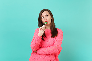 Puzzled young woman in knitted pink featuring azure, tiffany, and pastel