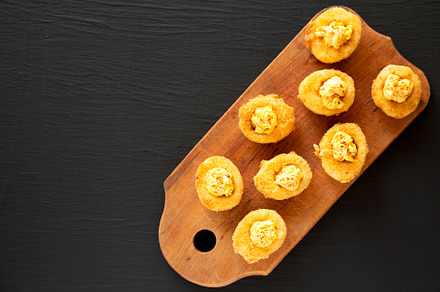 Homemade Deep-fried Deviled Eggs with Paprika on a rustic wooden, a Food & Drink Photo by LiudmylaChuhunova