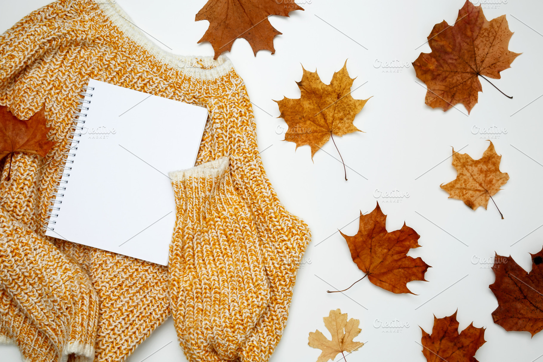 Autumn clothing. Warm golden sweater with mock up notebook. Top view. Copy spac, a Photo by matucha