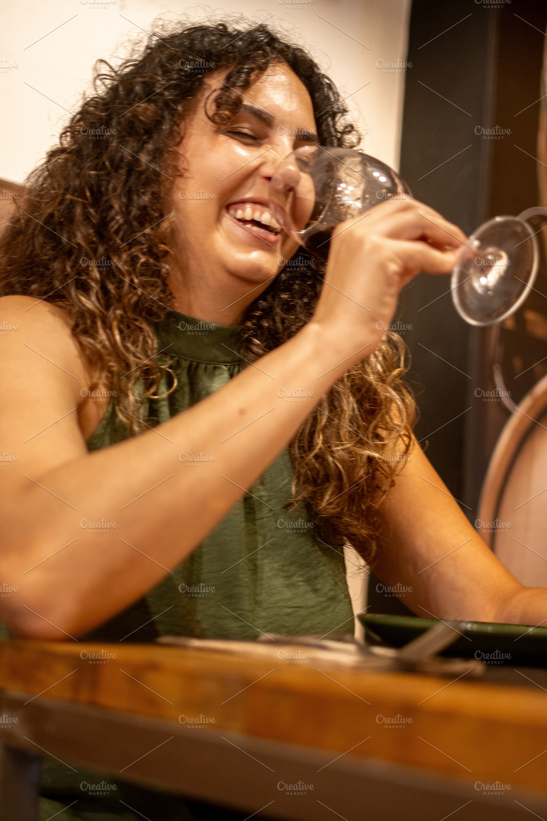 Happy woman drinking red wine and laughing during restaurant dinner, a Person Photo by etorres69