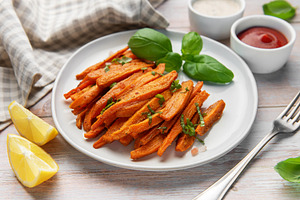 Roasted sweet potato fries on plate with basil and dipping sauce, a Food & Drink Photo by Olena Rudo