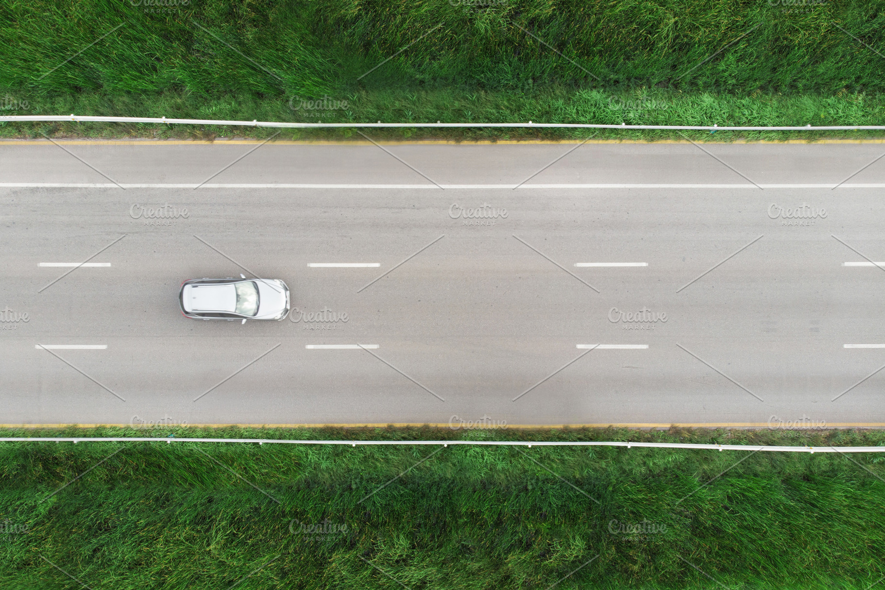 car on the street with green grass, a Transportation Photo by charnsitr