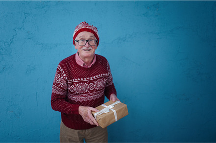 Portrait of happy senior man holding, a Holiday Photo by HalfPoint