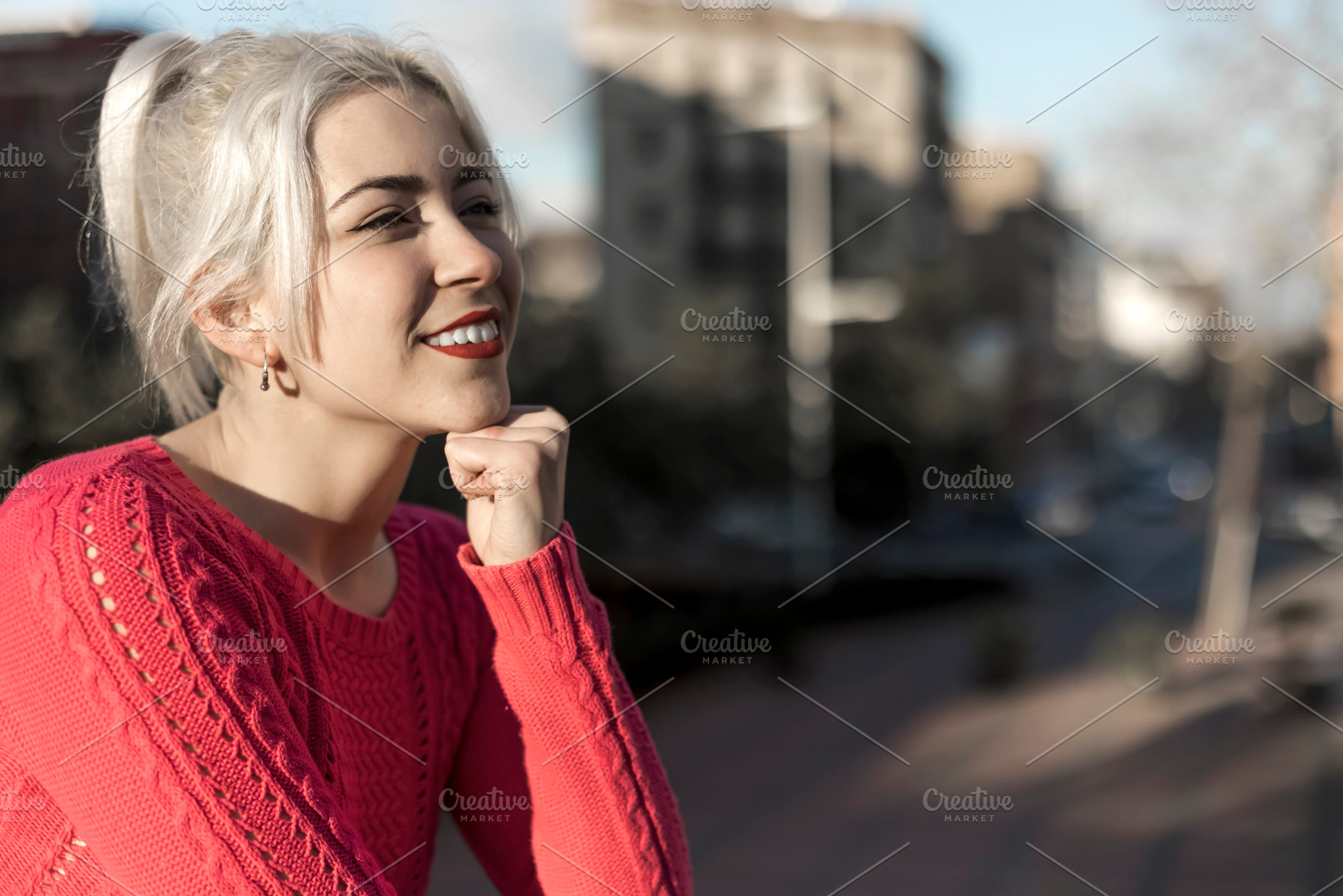 Slim young woman with blonde hair touching face and looking at camera while lea, a Person Photo by 2Design