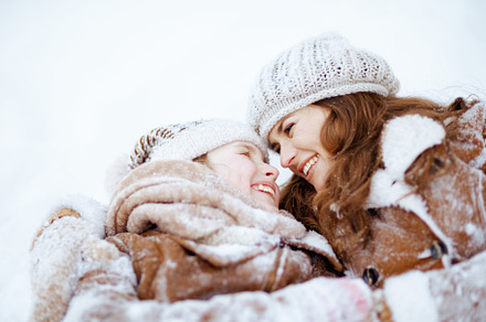 smiling elegant mother and child laying in snow, a Person Photo by Alliance Images