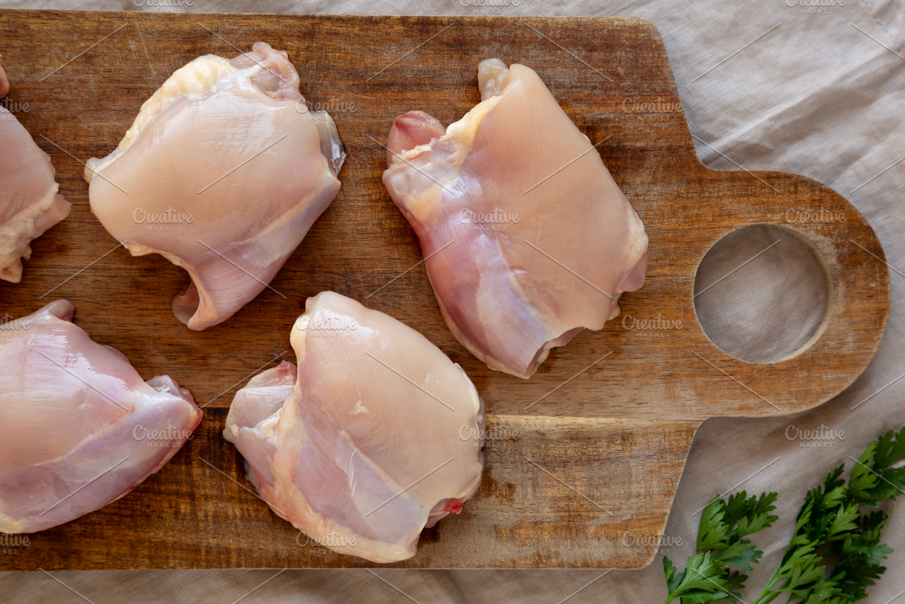 Raw Organic Boneless Skinless Chicken Thighs on a Wooden Board,, a Food & Drink Photo by LiudmylaChuhunova