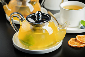 Fruit tea with mango and mint in a glass teapot on the table, a Food & Drink Photo by Budarinphoto