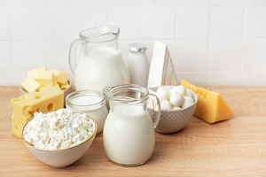 Assortment of fresh dairy products on wooden table, a Food & Drink Photo by Olena Rudo