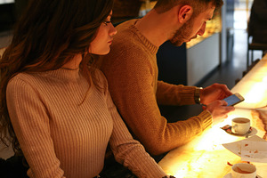 Jealous girlfriend spying on her boyfriend's cellphone at the bar, an Abstract Photo by Antonio Gravante Market