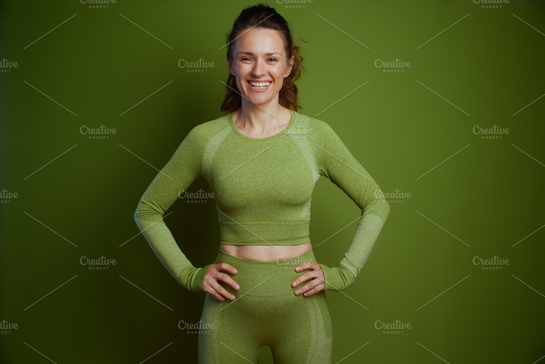 Smiling woman in green activewear, a Person Photo by Alliance Images