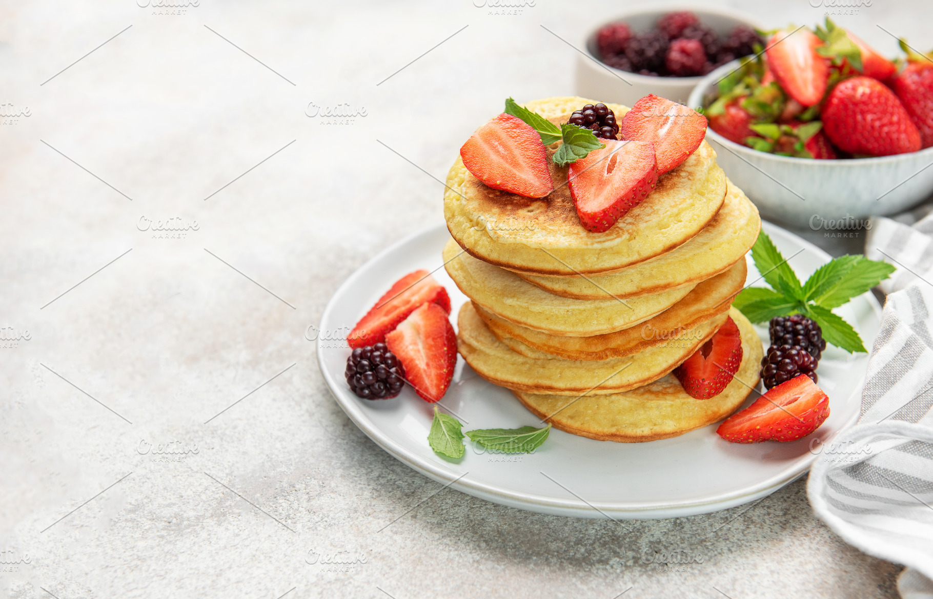 Stack of pancakes with strawberries and blackberries, a Food & Drink Photo by Olena Rudo