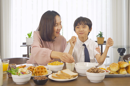 Portrait of happy smiling Asian Family eating breakfast food tog, a Photo by Tampatra