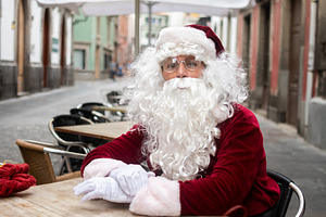 Santa Claus sitting at outdoor cafe terrace in city street, a Photo by etorres69