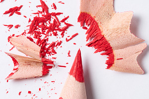 Wooden red shavings of lead pencil on white background, top view, an Abstract Photo by ndanko