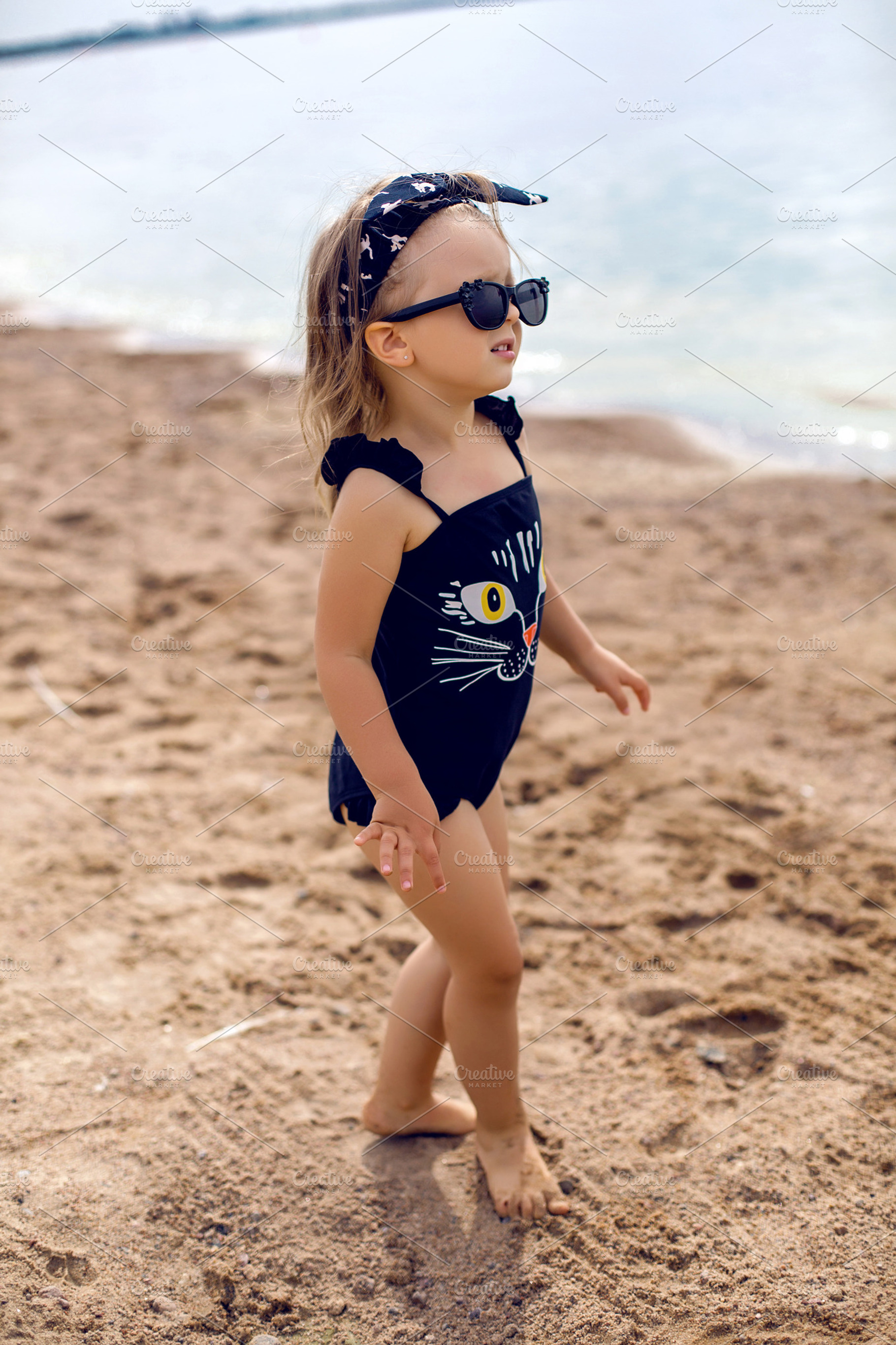 Little girl stands on the shore featuring child, shore, and kid, a Person Photo by SaulichPhoto