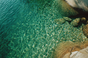 Clear water flows over rocks, a Photo by Pavel_design