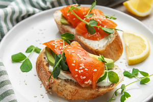 Salmon avocado toasts with microgreens and lemon, a Food & Drink Photo by Olena Rudo