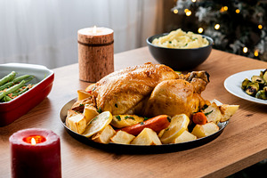 Whole roasted chicken with potatoes and vegetables.
