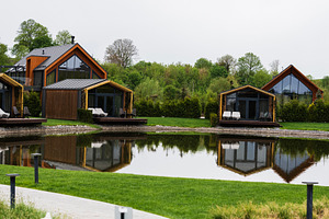 Modern wooden cabins by a serene lake surrounded by greenery and tranquility, a Photo by AS photostudio